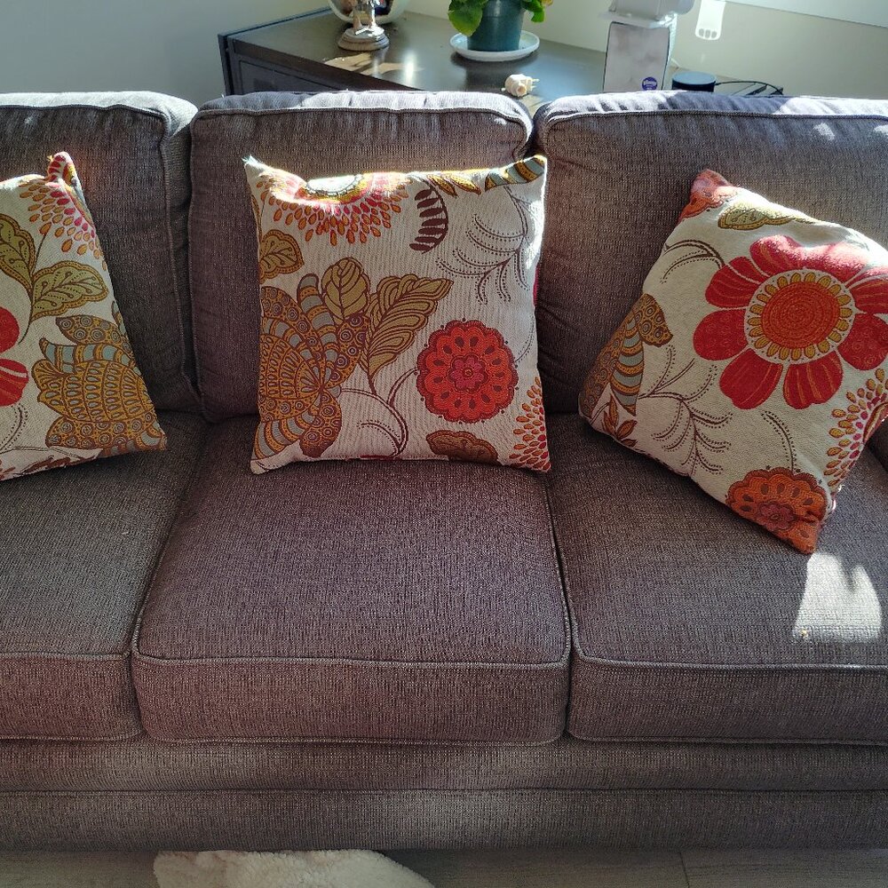 Three neutral background abstract floral and leaf accent pillows.